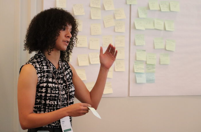 Woman presenting at 2025 Super Summit with Post-Its behind her