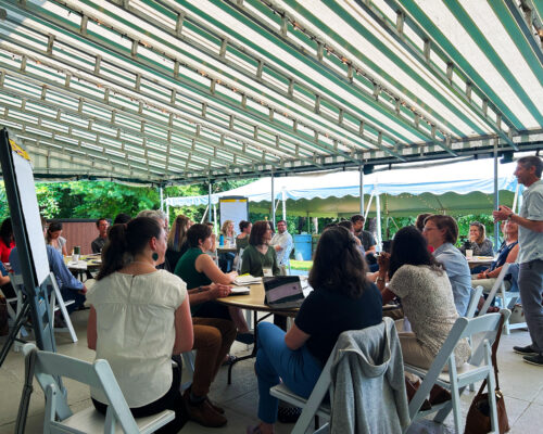 Nadav Malin leading discussion in covered outdoor seating area
