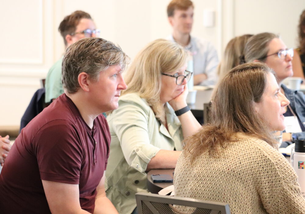 People at table listening at 2025 Super Summit